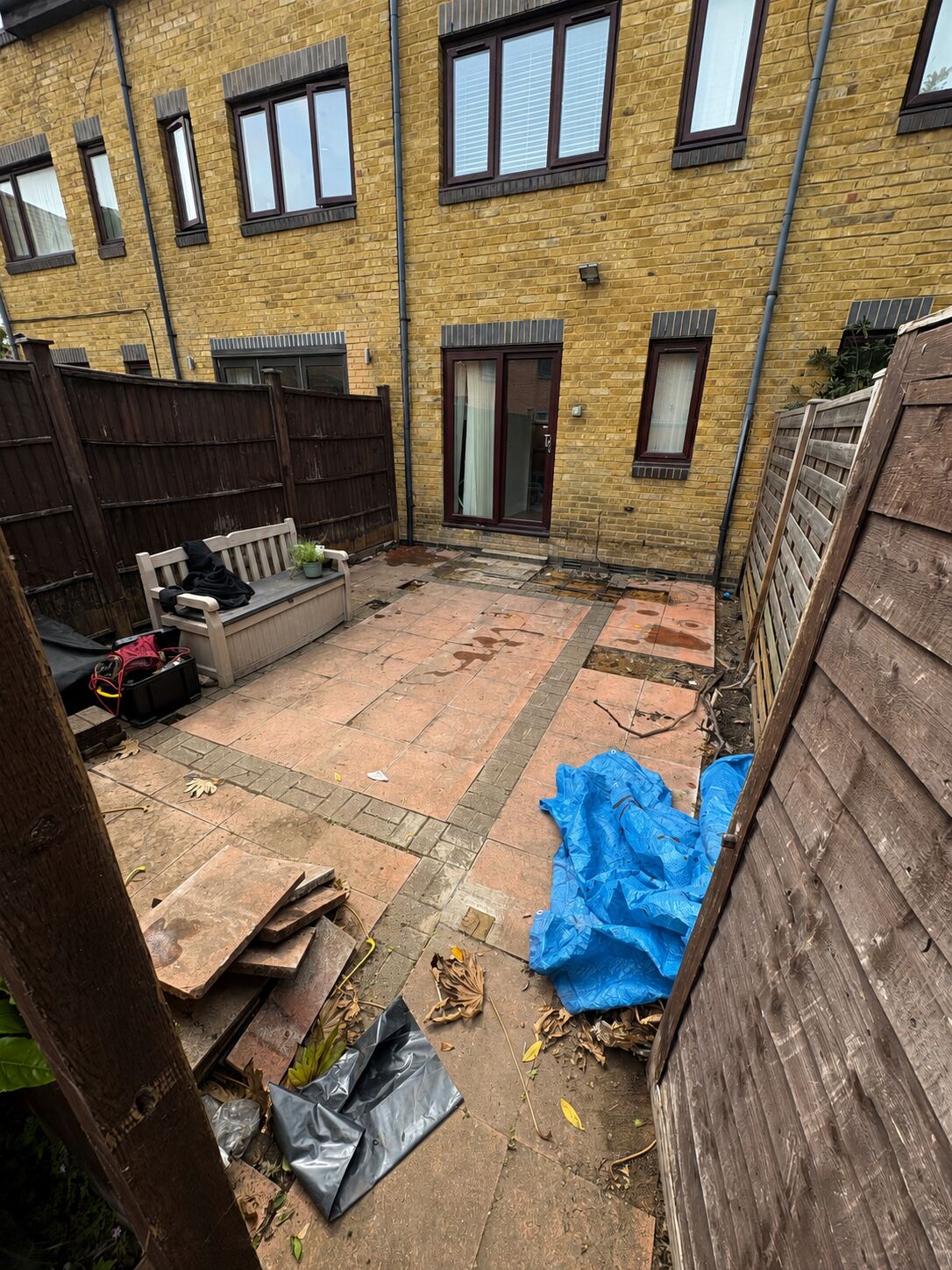 Before: cracked patio and bare fence